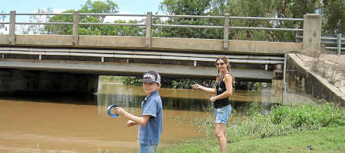 Narelle Nixon and Mitchell Power, of Southport, try their luck fishing in the swollen waters of the Mcintyre Brook at Inglewood during an enforced stay in the town following road closures to the east and west of the town on Wednesday. Narelle Nixon and Mitchell Power, of Southport, try their luck fishing in the swollen waters of the Mcintyre Brook at Inglewood during an enforced stay in the town following road closures to the east and west of the town on Wednesday.